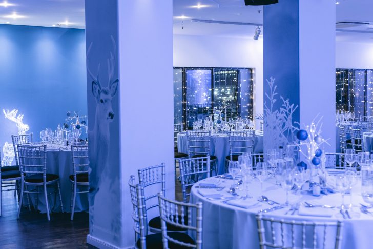 christmas party venue, christmassy, festively decorated, cabaret style, reindeer on the wall