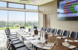 view of the outside, boardroom, TV screen, water bottles and water glasses