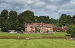 front exterior of burley manor, surrounded by acres of land