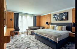 hotel suite, sofa beside bed, chair in the corner, natural daylight