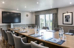 plasma screen, natural daylight, clock on wall, modern boardroom, comfy meeting room chairs