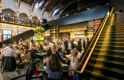 close up view of people eating and chatting, event space, chairs and tables near the stairs