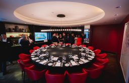 round table, red chairs, meeting room, drinks reception in action, plasma screen