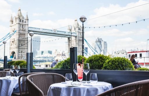 outdoor space, outdoor seating, view of tower of London, cocktail, wine and water glasses on table