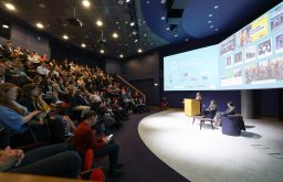 auditorium, lecturn, projector screens, stage with conference speakers