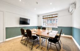 plasma tv screen, water on the tables, natural daylight, unique conference venue