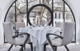 table nicely set out in front of the window, dining area