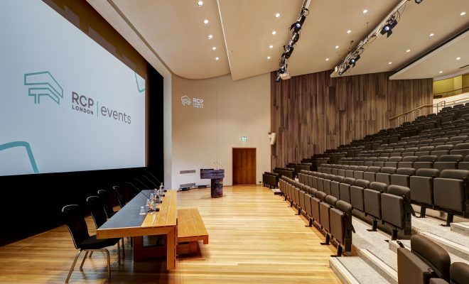 projector screen, head speaker table, refurbished auditorium, conference space, lecturn at the side of the room