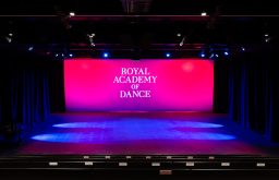 stage, projector screen showcasing royal academy of dance, auditorium