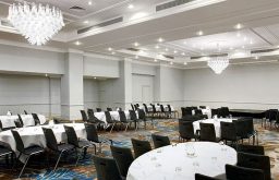 large conference room, cabaret layout, stage area in the front, conference, chandeliers