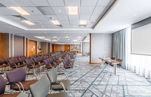 theatre layout, modern conference room, natural daylight, projector screen